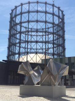 Four parts of a cube in front of the gasometer